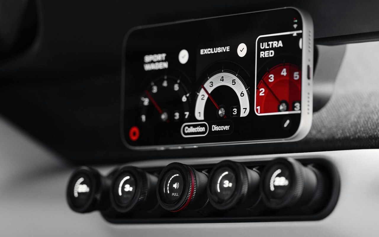Interior of Porsche Mission S vision model showing analogue buttons with integrated MagSafe smartphone fixture for navigation and information
